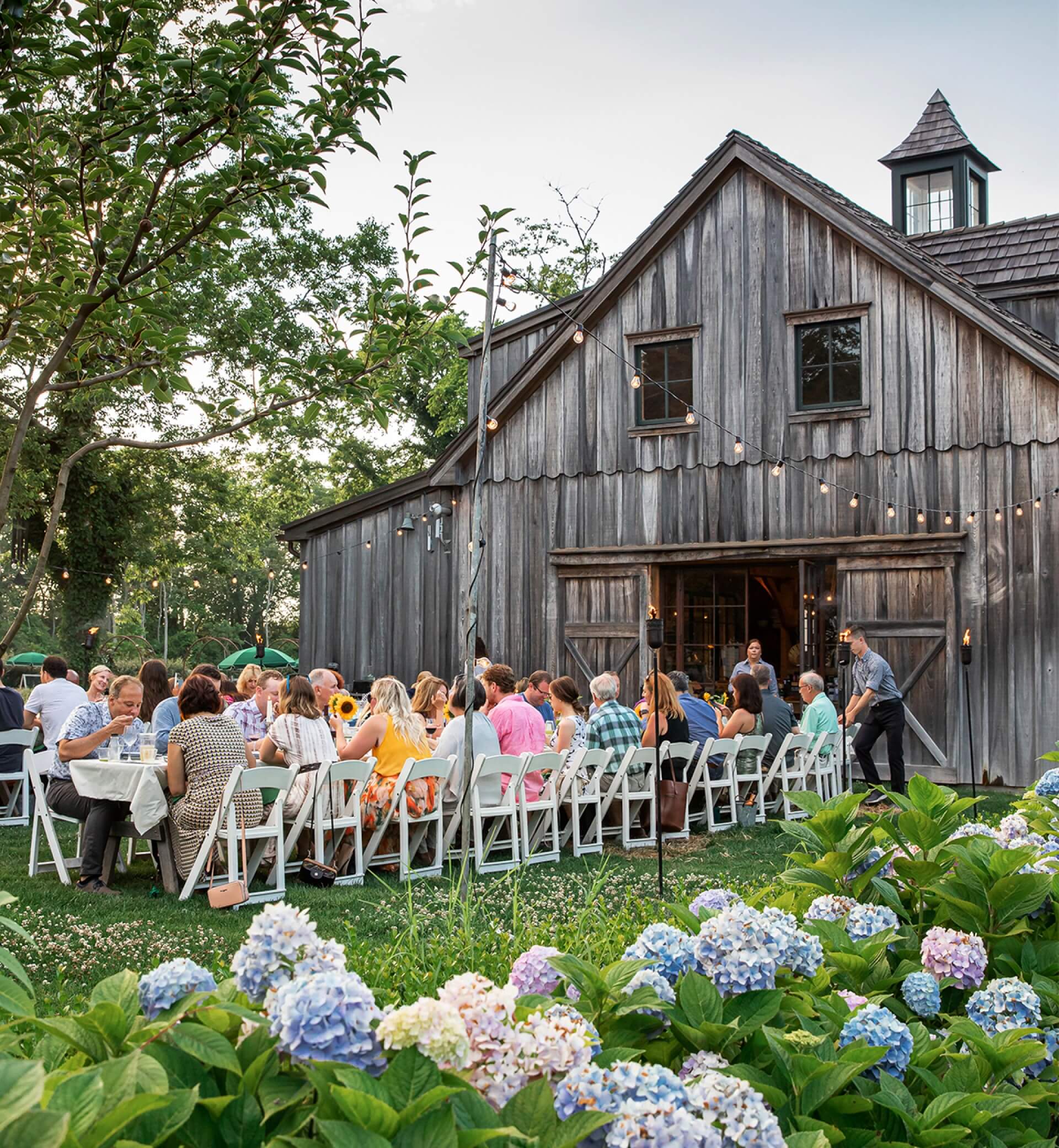 people eating at outdoor communal table outside beach plum farm barn