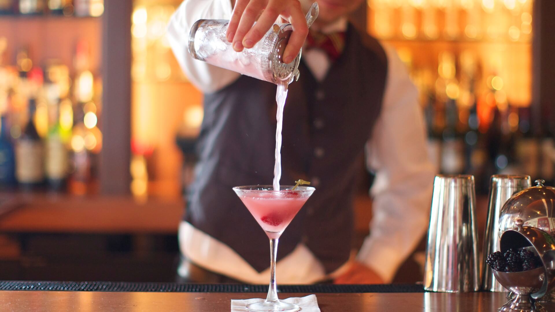 man pouring a cocktail at the ebbitt room bar