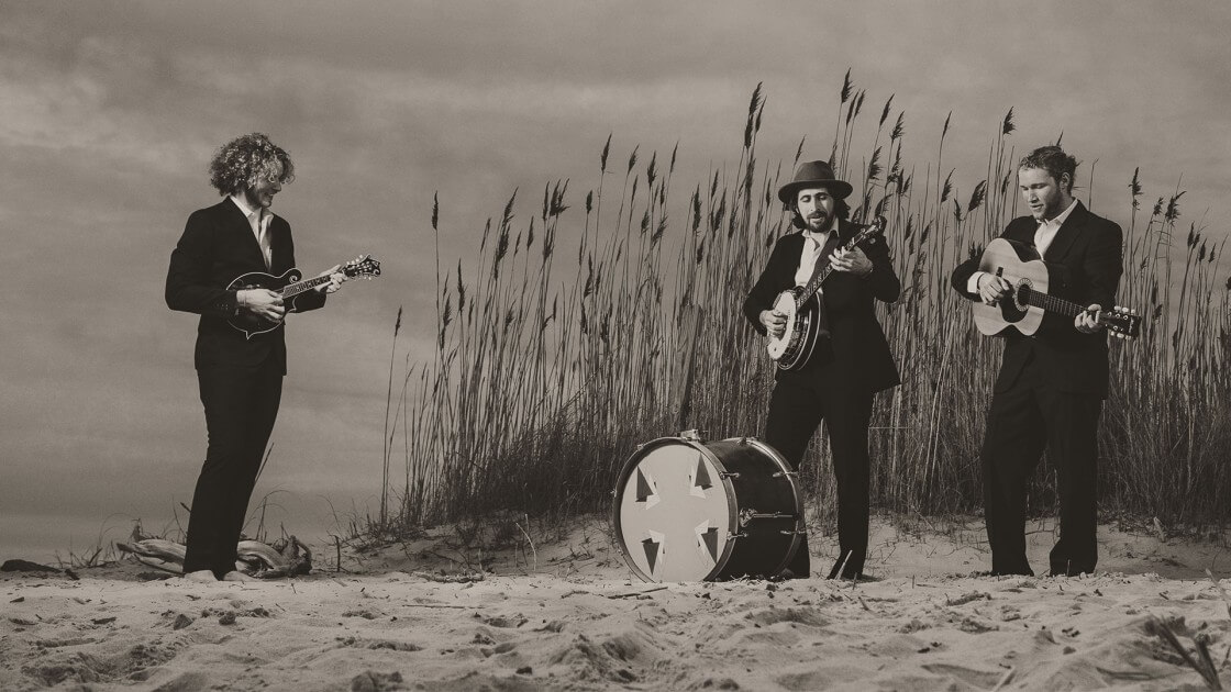 Men playing guitar on sand dunes