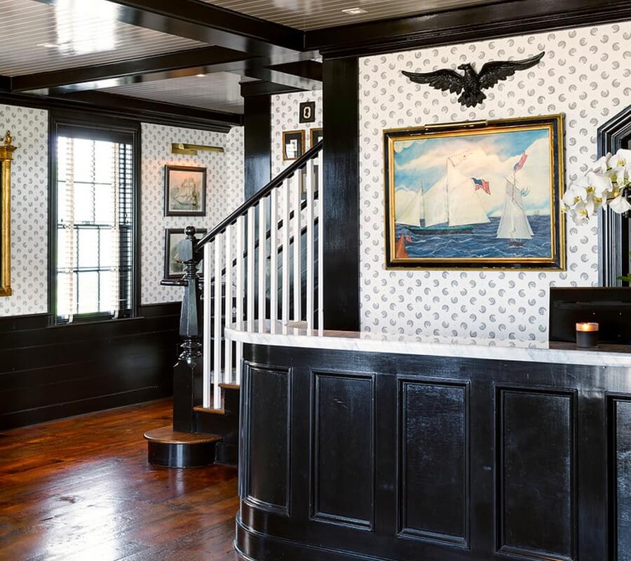 Baron's Cove lobby with white wallpaper and a black-painted desk