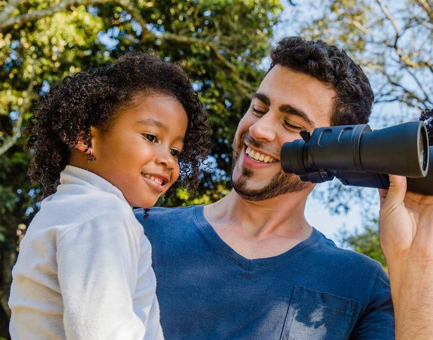 father and son holding binoculars